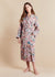 Woman wearing a floral patterned lightweight robe on a beige background